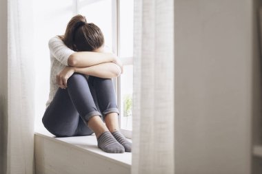 Sad pencere yanında oturan kadın bitkin, yorgun ve yalnız bir kız