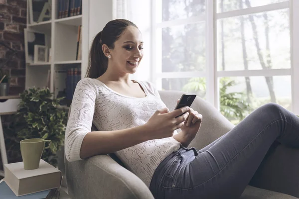 Glad Ung Flicka Med Hjälp Smartphone Hemma Hon Kopplar Fåtöljen — Stockfoto