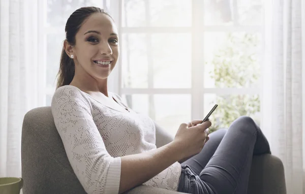 Chica Joven Feliz Usando Teléfono Inteligente Casa Ella Está Relajando — Foto de Stock