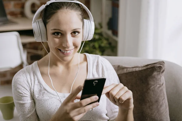 Gelukkig Jongedame Luisteren Naar Muziek Thuis Met Haar Smartphone Aansluiten — Stockfoto