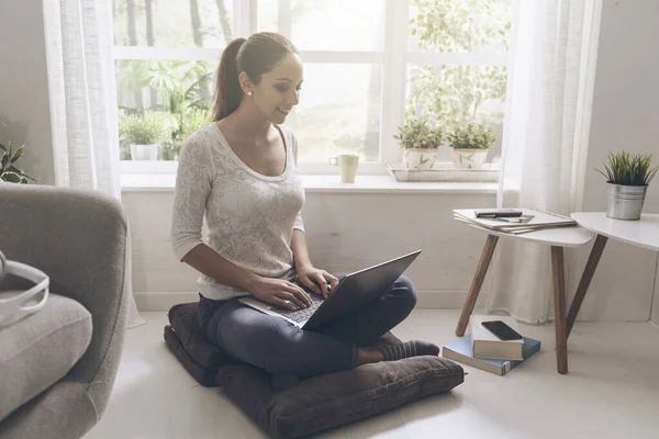 Evde Bilgisayarına Bağlanan Gülümseyen Genç Bir Kadın Yerde Oturmuş Sohbet — Stok fotoğraf