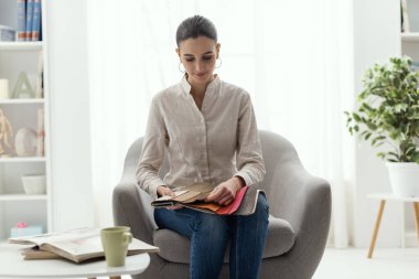 Koltuk için en iyi döşemeyi seçen genç kadın.