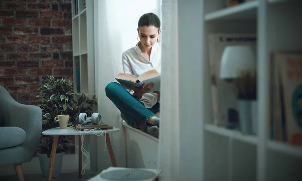 Joven Mujer Serena Relajándose Casa Leyendo Libro Lado Una Ventana —  Fotos de Stock