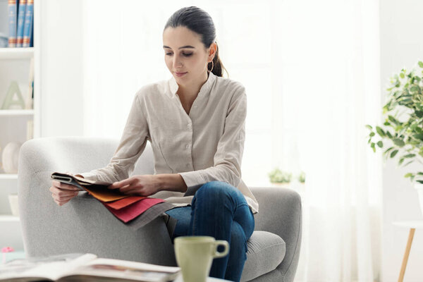 Young woman choosing the best upholstery for the armchair