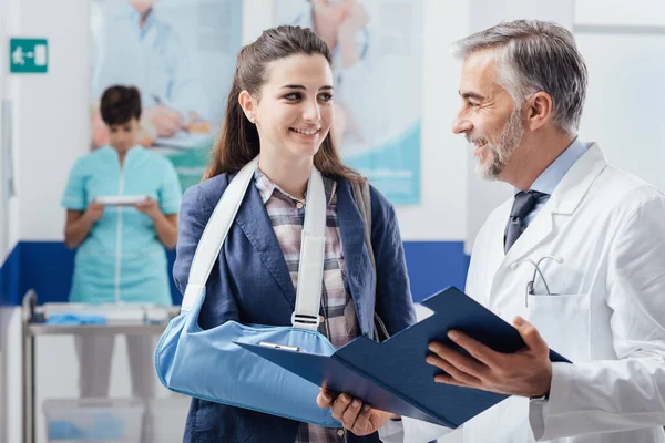 Médico Sonriente Profesional Visitando Una Paciente Con Brazo Roto Revisando —  Fotos de Stock