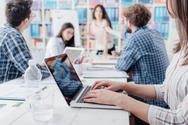 Genç iş adamları ofiste toplanıyor ve beyin fırtınası yapıyorlar. Strateji ve projeleri birlikte tartışıyorlar. Girişimler ve takım çalışması kavramı.