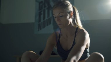 Spor salonunda esneme egzersizleri yapan atletik kaslı kadın, spor ve spor konsepti.