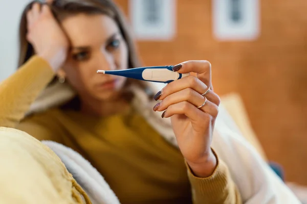 Mujer Enferma Sentada Sofá Casa Midiendo Temperatura Con Termómetro Tiene — Foto de Stock