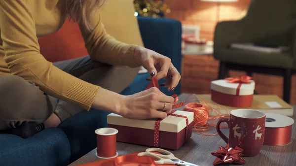 Vrouw Bereidt Kerstcadeaus Thuis Voor Zit Bank Bindt Een Lint — Stockfoto