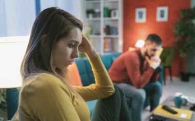 Evde kavga eden genç bir çift: üzgün, oturan ve düşünen, ilişki sorunları konsepti