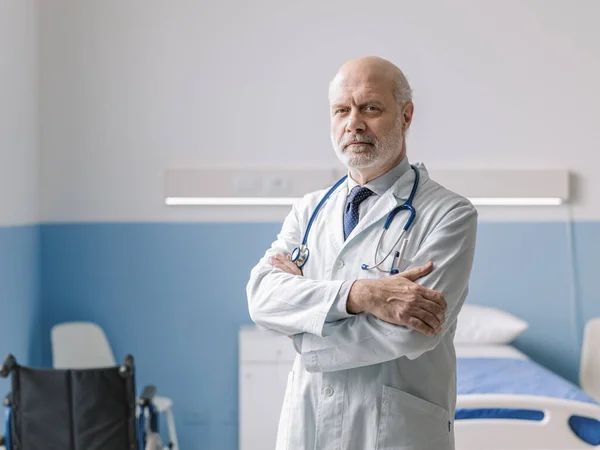 Médico Profissional Lado Uma Cama Hospital Posando Com Braços Dobrados — Fotografia de Stock