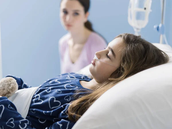 Jovem Mãe Assistindo Sua Filha Doente Deitada Cama Hospital — Fotografia de Stock