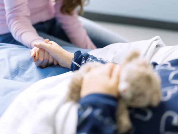 Kochająca Młoda Matka Asystująca Córce Szpitalnym Łóżku Trzymają Się Ręce — Zdjęcie stockowe