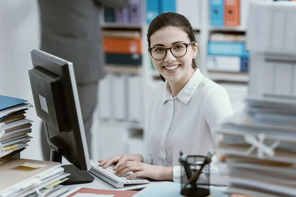 Mladá Usměvavá Sekretářka Pracující Kancelářském Stole Hromádky Papírů — Stock fotografie