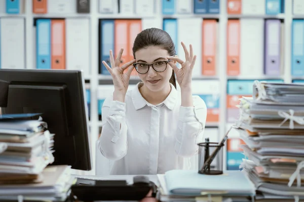 Γραμματέας Αυτοπεποίθηση Κάθεται Στο Γραφείο Και Προσαρμόζει Γυαλιά Της — Φωτογραφία Αρχείου