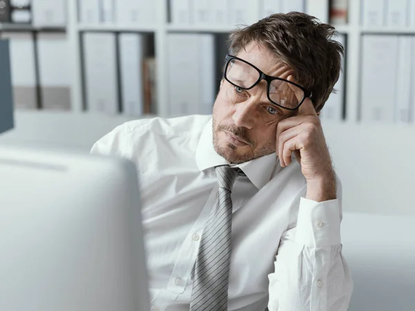 疲惫不堪的企业主管 靠着自己的电脑工作 靠在自己的胳膊 压力和过度工作的观念上 — 图库照片