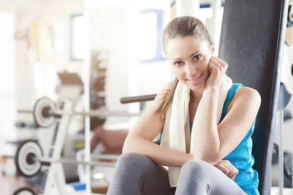 Attraktive Lächelnde Frau Fitnessstudio Entspannt Sich Auf Der Trainingsgerätebank — Stockfoto