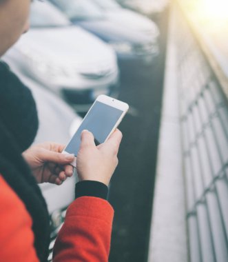 Şehirde tanınmayan bir kadın akıllı telefonuyla mesajlaşıyor.