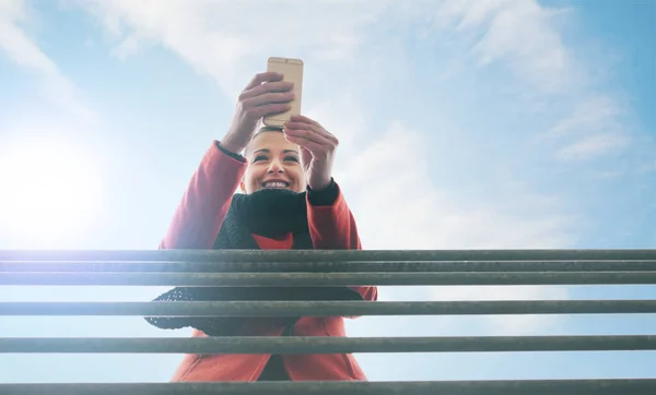 Usmívající Žena Opírající Zábradlí Smskování Mobilem Obloha Pozadí — Stock fotografie