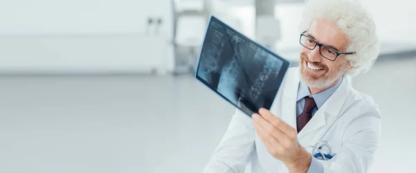 Selbstbewusster Arzt Sitzt Schreibtisch Und Untersucht Das Röntgenbild Eines Patienten — Stockfoto