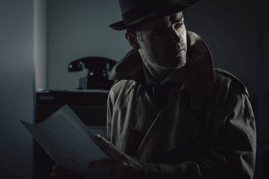 Eski bir gizli ajan gece geç saatlerde bir şirket ofisinde dosya çalıyor, güvenlik ve veri hırsızlığı kavramı.