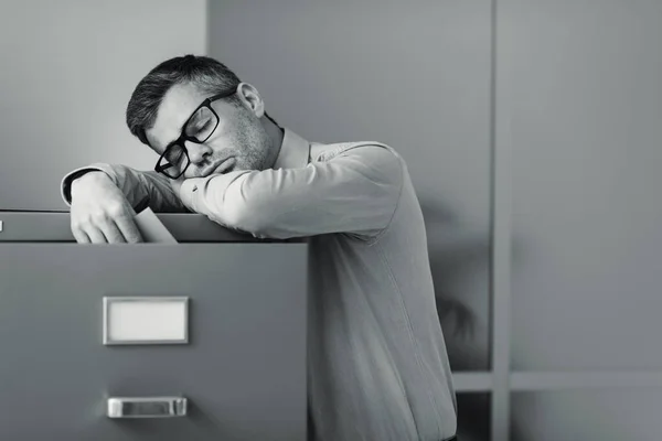 Müder Fauler Büroangestellter Der Sich Auf Einen Aktenschrank Lehnt Und — Stockfoto