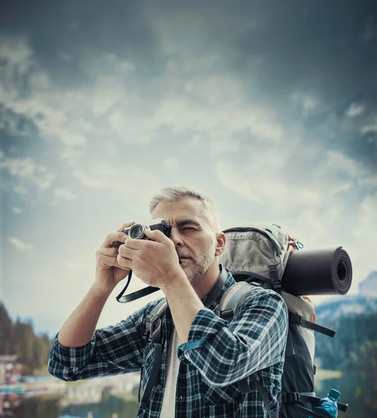 摄影师和探险家正在登山和探索自然 他正在用相机拍照 — 图库照片