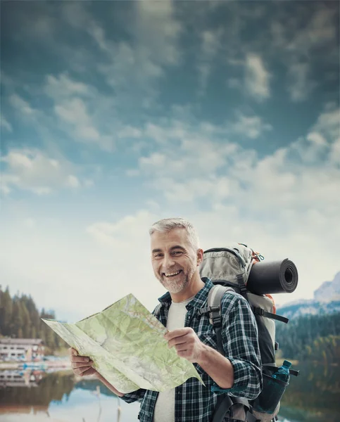 山の上で成熟したハイカーのトレッキングを笑顔と地図上の方向を検索 スポーツや旅行の概念 — ストック写真
