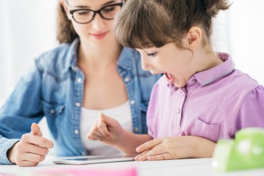 Dijital tablet, eğitim ve teknoloji kullanan öğretmen ve kız