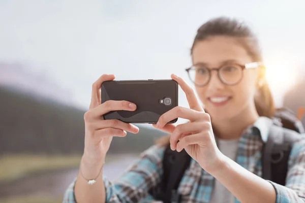 Молодая Улыбающаяся Женщина Путешествующая Горах Фотографирующая Своим Смартфоном Сенсорным Экраном — стоковое фото