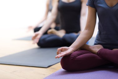Yoga yapan ve lotus pozunda oturan kadınlar: farkındalık meditasyonu, maneviyat ve sağlıklı yaşam tarzı kavramı