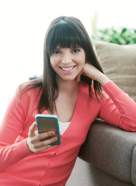 집에서 편안하게 매력적 여자의 메시지와 워킹을 스크린 스마트폰으로 — 스톡 사진