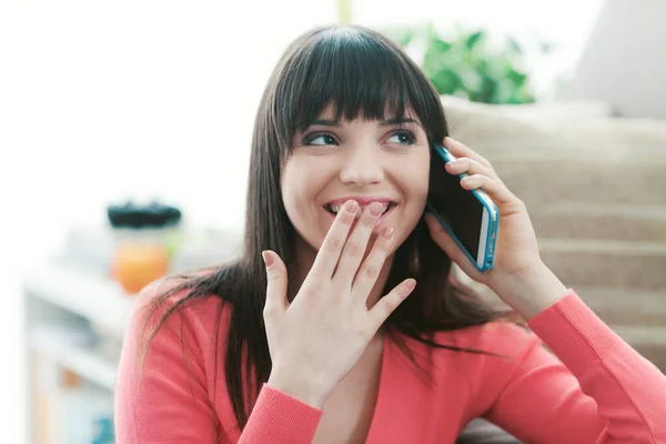 Привлекательная Женщина Разговаривает Телефону Своим Смартфоном Хихикает Закрывая Рот Рукой — стоковое фото