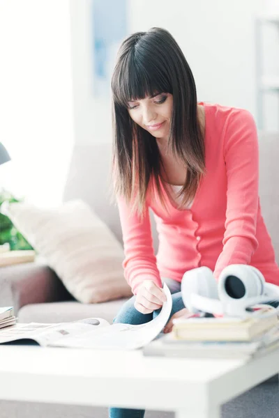 家でリラックスしている魅力的な若い女性 彼女はソファに座って雑誌を読んでいます — ストック写真
