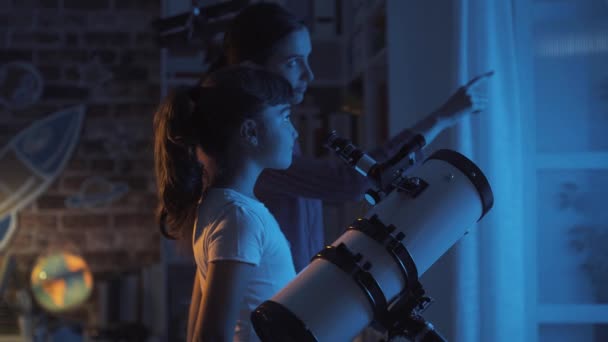 Счастливые сестры смотрят на звезды с помощью телескопа — стоковое видео