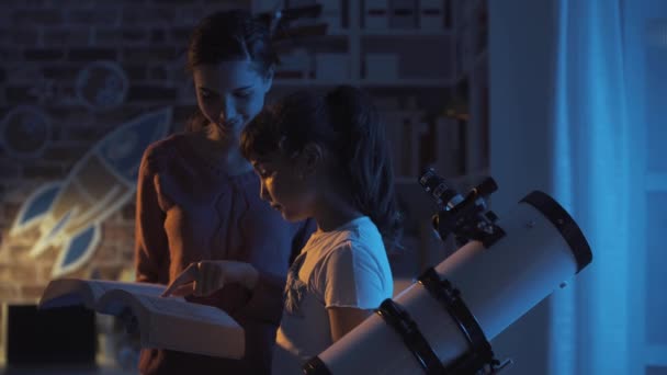 Jovens irmãs assistindo estrelas com um telescópio à noite — Vídeo de Stock