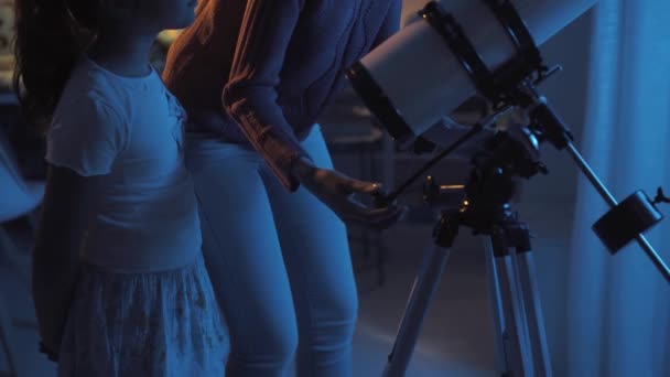Kız kardeşler profesyonel bir teleskopla yıldızları izliyorlar. — Stok video