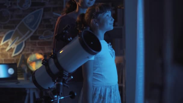 Sestry hledící na hvězdy společně s profesionálním dalekohledem — Stock video