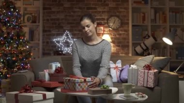Bir sürü Noel hediyesi olan neşeli bir kadın.