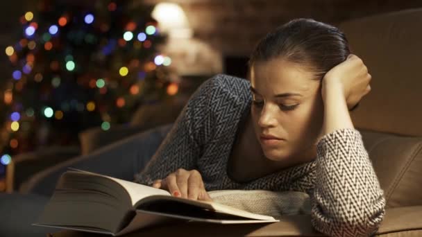 Vrouw leest een boek en ontspant zich op Kerstmis — Stockvideo