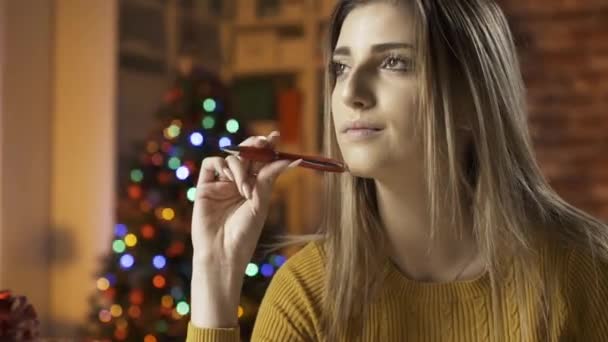 Mulher sorridente escrevendo um cartão de Natal com desejos — Vídeo de Stock