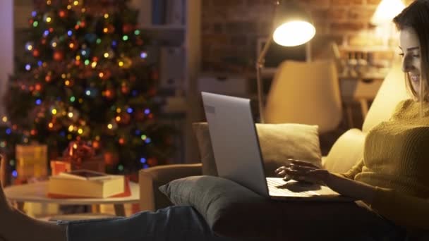 Lachend schattig meisje chatten online op kerstavond — Stockvideo