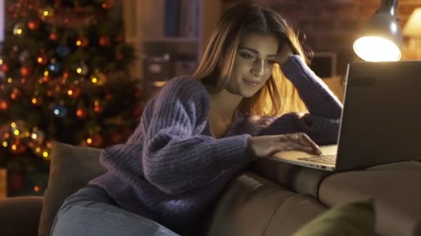 Lachend schattig meisje chatten online op kerstavond — Stockvideo