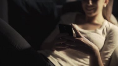 Mutlu kız gece geç saatlerde akıllı telefonuyla sohbet ediyor.