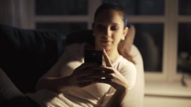 Mutlu kız gece geç saatlerde akıllı telefonuyla sohbet ediyor.