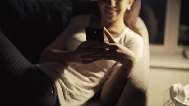 Mutlu kız gece geç saatlerde akıllı telefonuyla sohbet ediyor. — Stok video