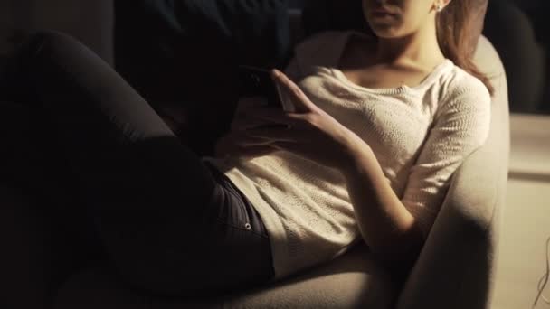 Szczęśliwa dziewczyna rozmawia późno w nocy ze swoim smartfonem — Wideo stockowe