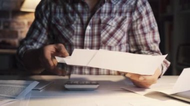 Adam ev hesaplarını ve faturaları kontrol ediyor.