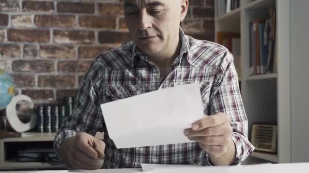 Disappointed man checking his home finances — Stock Video