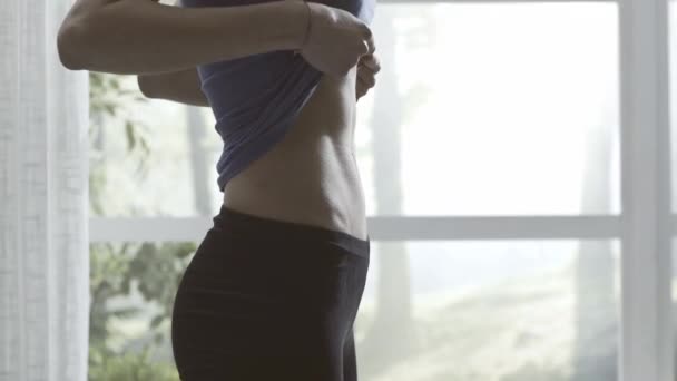 Mladá žena ukazuje své ploché břicho